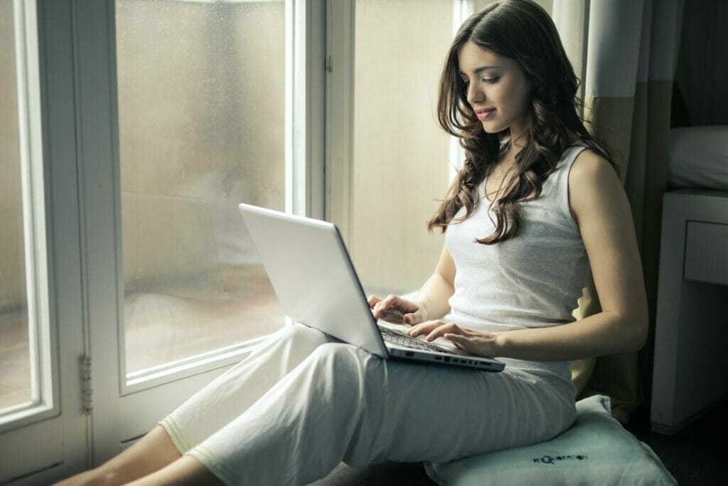 laptop gebruiken - Photo by Andrea Piacquadio: https://www.pexels.com/photo/woman-wearing-tank-top-sitting-by-the-window-920381/